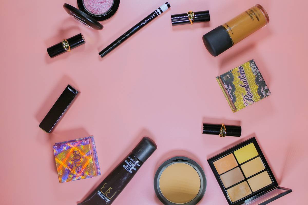 Flat lay featuring makeup and beauty items of a female traveler.