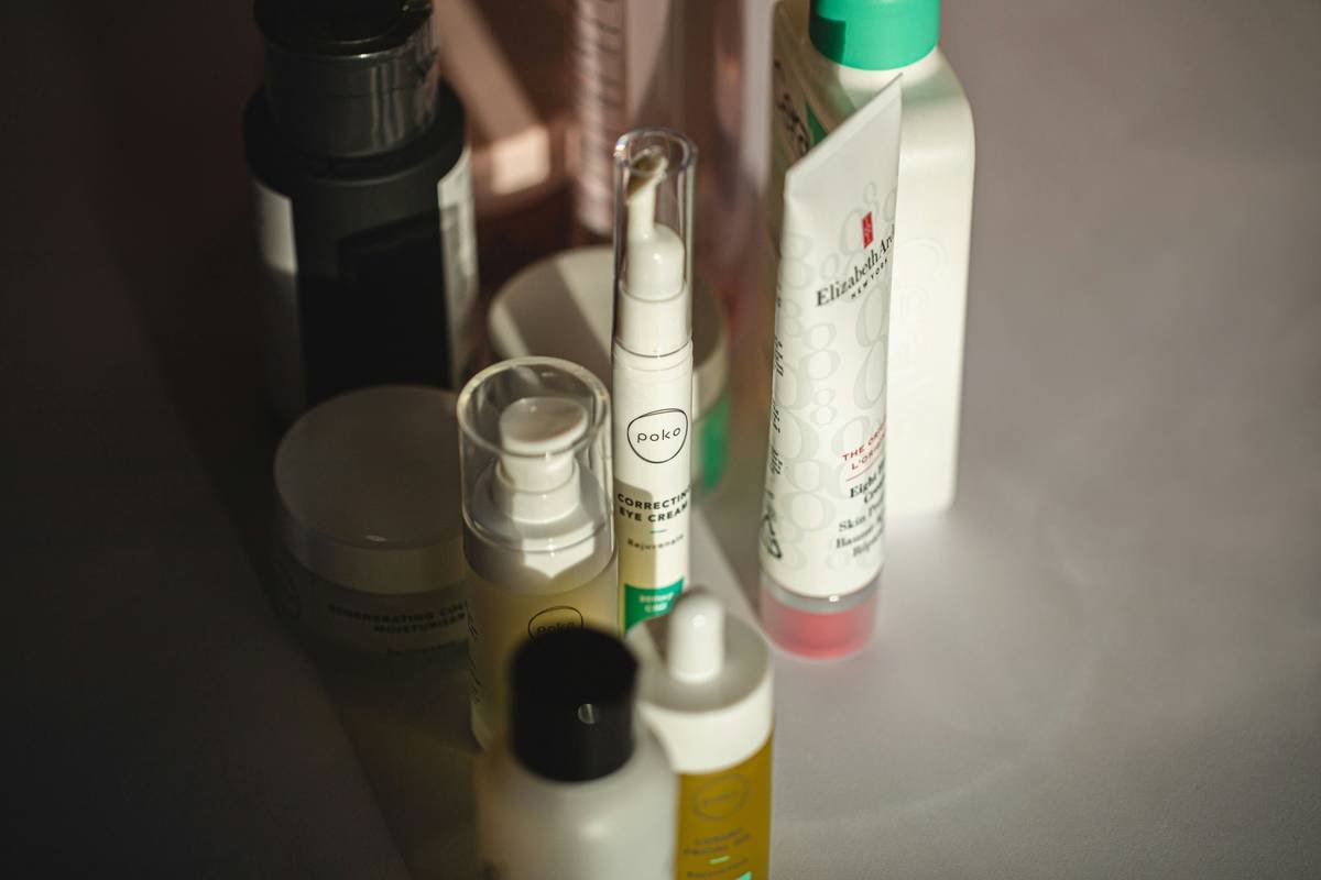 close-up of gentle cosmetic sensitive skin make up products lined up on marble surface with dermatologist hand testing