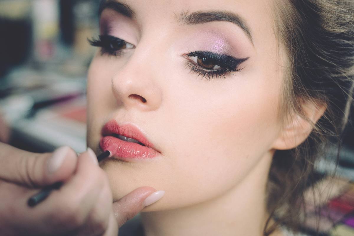 Woman applying lightweight makeup for sensitive skin with clean fingertips using tinted serum