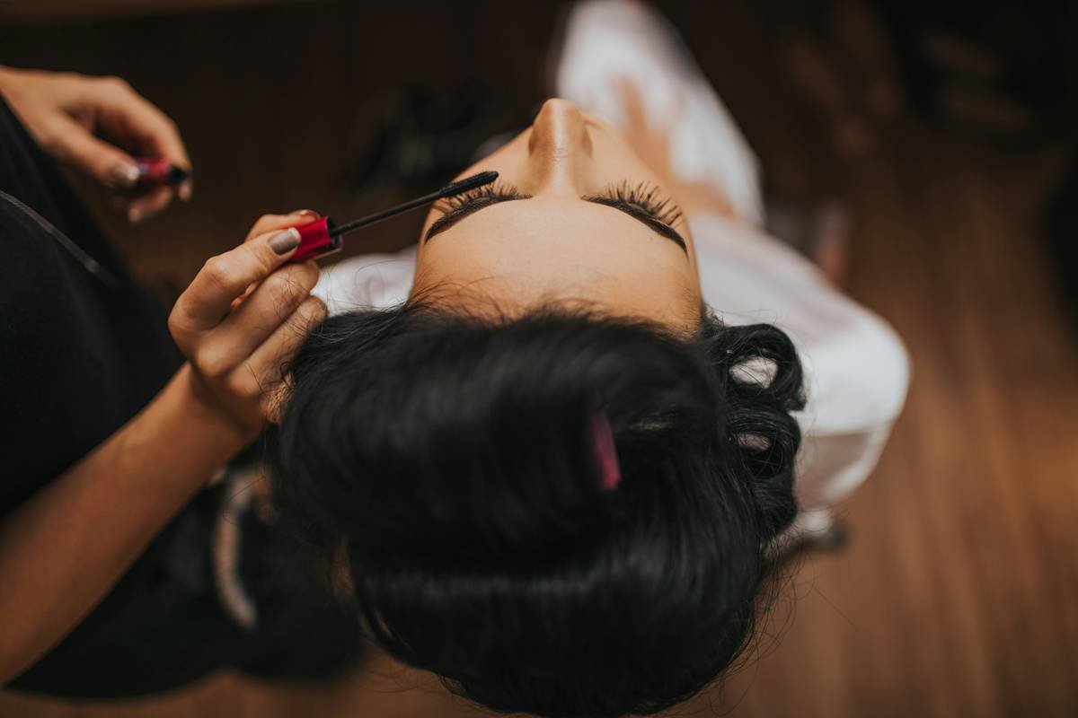 Woman applying hypoallergenic eyeshadow with clean brushes, demonstrating safe makeup for sensitive eyes