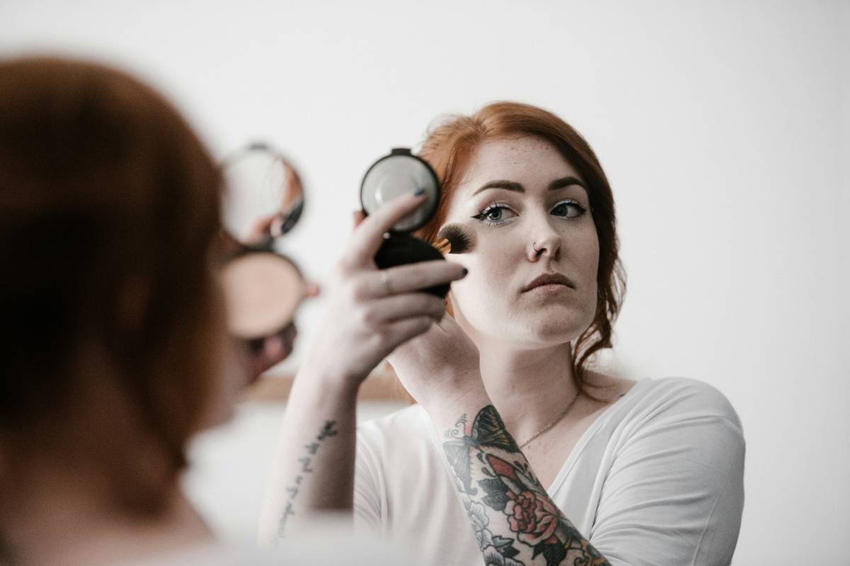 Woman applying gentle cosmetic sensitive skin is magic mineral foundation with clean fingertips